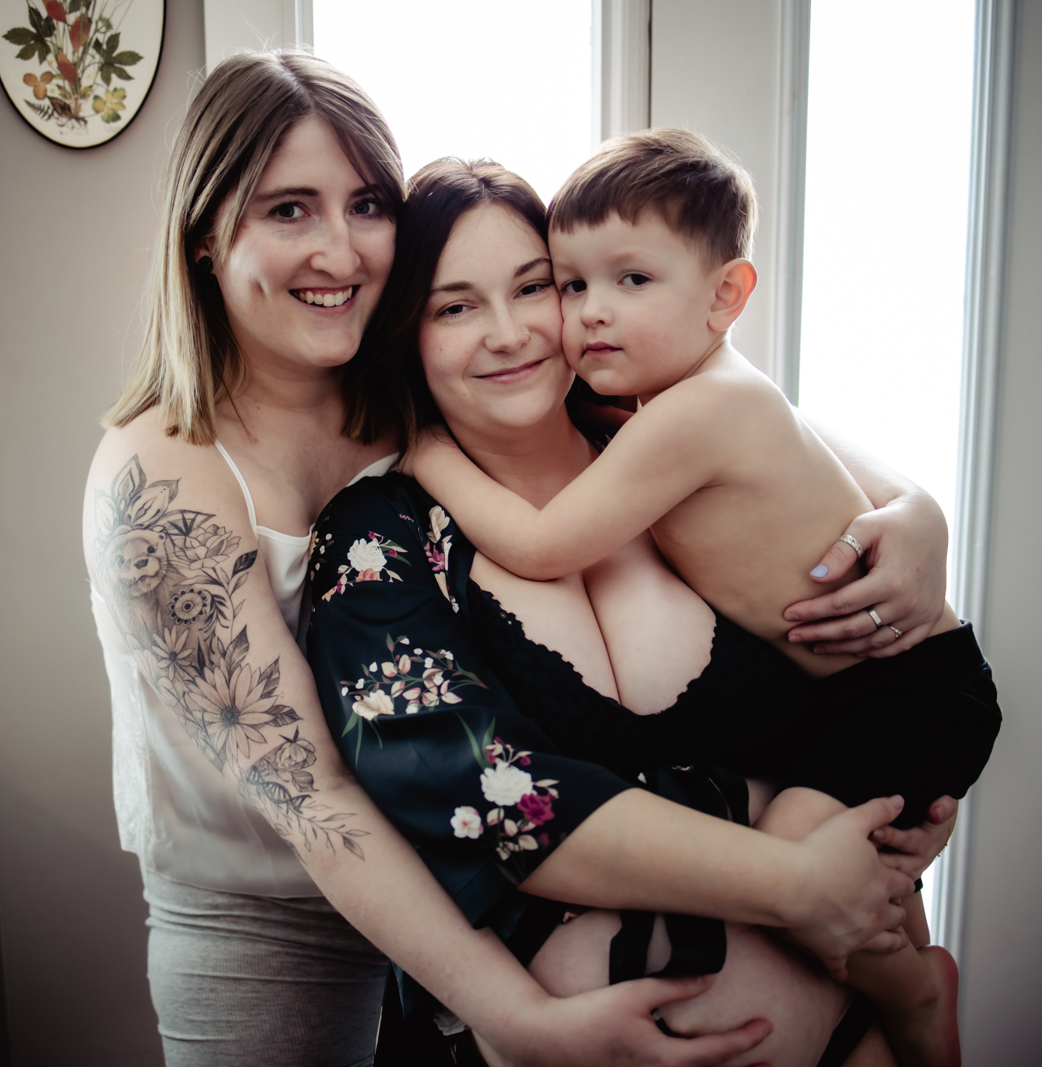 A close-up of a smiling couple holding their young child, highlighting emotional connection and warmth in a home-based family photography portrait.