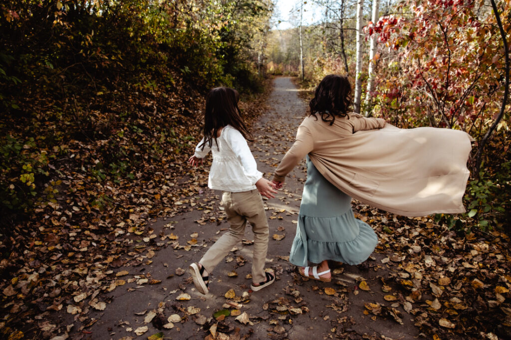 two girls playing in a fall forest