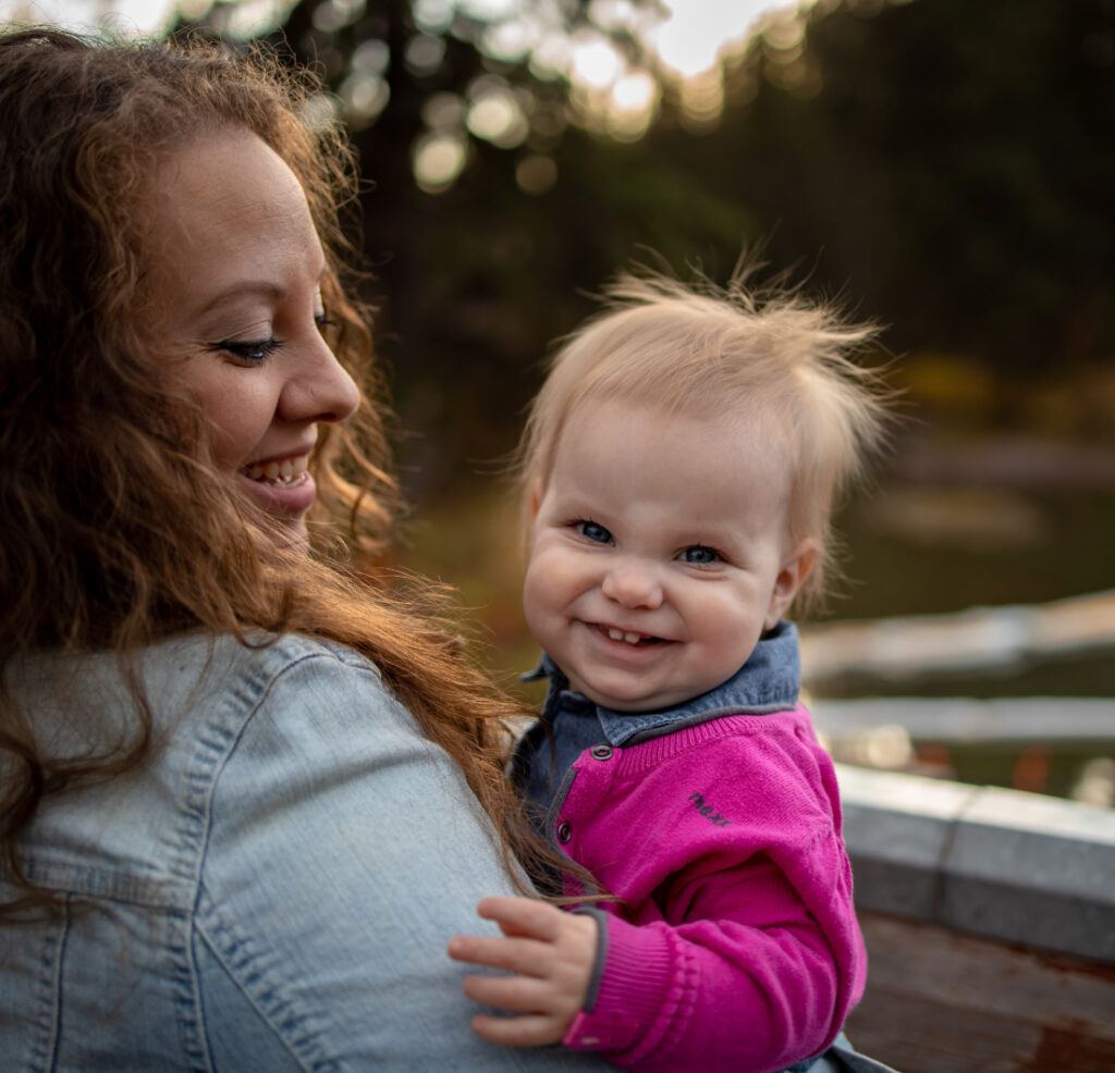 A mother holding her baby close during a golden hour family session in Edmonton.