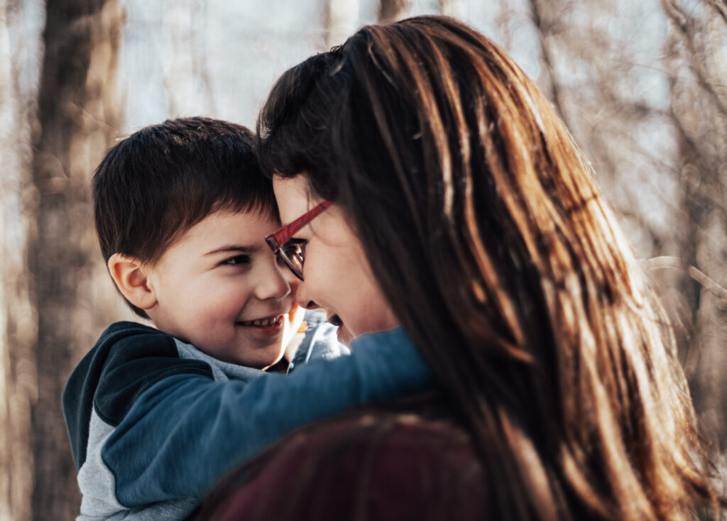 A close-up of a parent and child sharing a tender moment during an outdoor family session at one of the wooded photoshoot locations Edmonton families love.