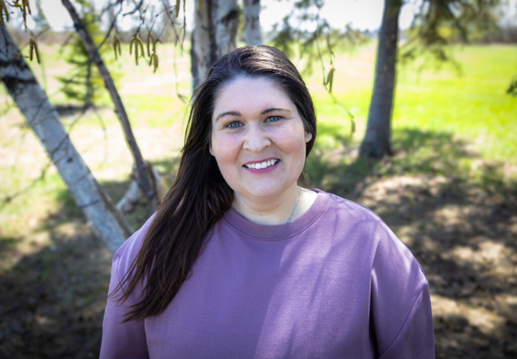 Portrait of a birth support provider smiling outdoors, one of the compassionate professionals serving families through Edmonton doulas and midwives care.