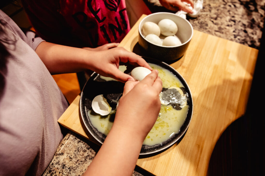 My daughters carefully cracking open non-viable eggs while hatching duck eggs together as a family, learning about nature and the different stages of development.